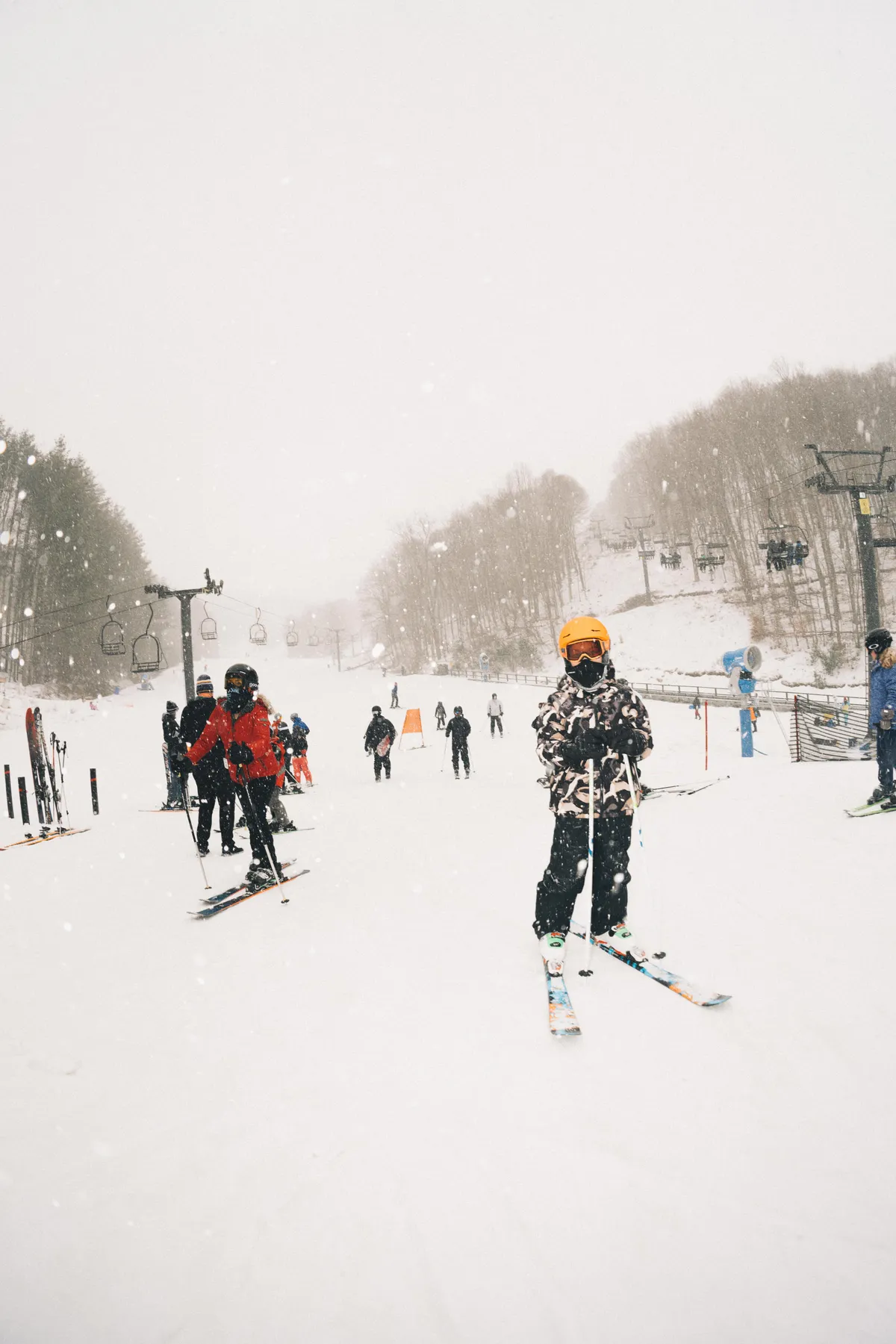 This image features skiers actively navigating snow-covered slopes, a ski lift in operation, and a wide vista of a wintry landscape. The scene is lively, capturing the thrill and adventure that Wolf Ridge Ski Resort offers visitors of all experience levels.