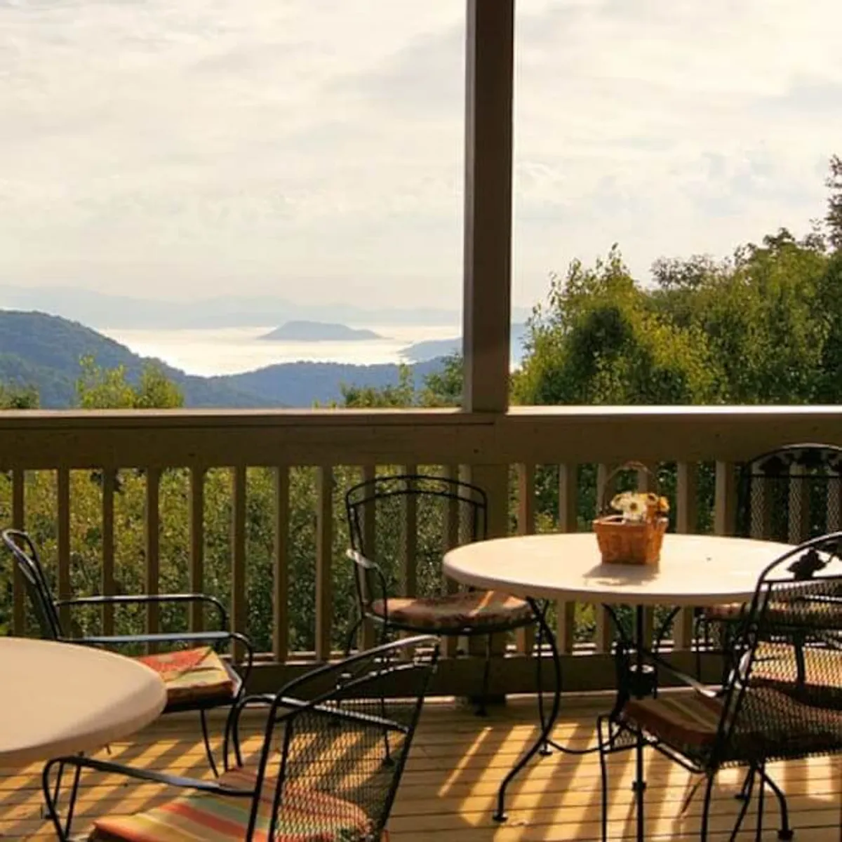 Outdoor seating and a table adorned with flowers, set against a panoramic mountain view. The peaceful tableau is ideal for morning coffee, afternoon relaxation, or stargazing, offering a direct connection to the surrounding natural beauty.